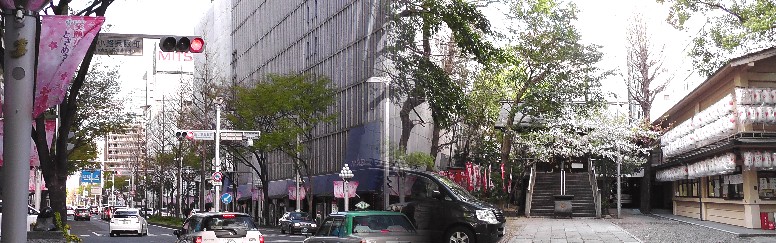 広小路通り丸栄百貨店すぐ西、北側歩道を覆い昼なお暗い森が朝日神社（右）です。 左は神社前の広小路通りです。 朝日神社御由緒 リンク:朝日神社