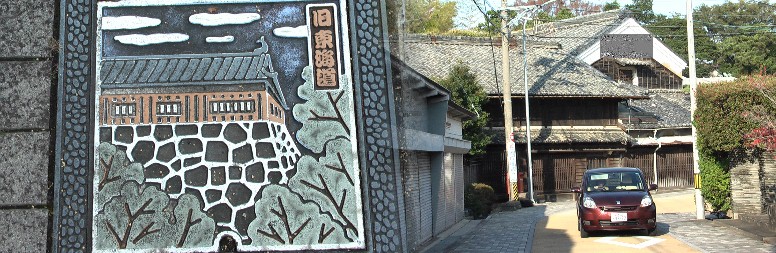 旧東海道の歩道埋め込み道標と街並み。