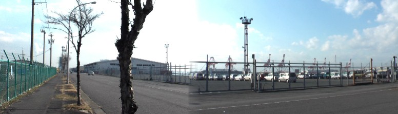 金城埠頭西側岸壁は海運・倉庫など企業用地で立ち入り禁止です。写真は埠頭を南北に縦貫する 西側道路、左は南方を撮る。右写真キリンのようなクレーンは対岸の飛島コンテナ埠頭。