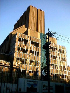 駅から南東へ約1.3キロ、 東山公園を通り抜けた山中に建つ巨大なビル (約20階建て)が完成間近い、 およそ回りの風景にそぐわない建物です。 環境に配慮された換気所の建物です。 この下を通る都市高速1号線 四谷~高針間(地下トンネル)の緑橋