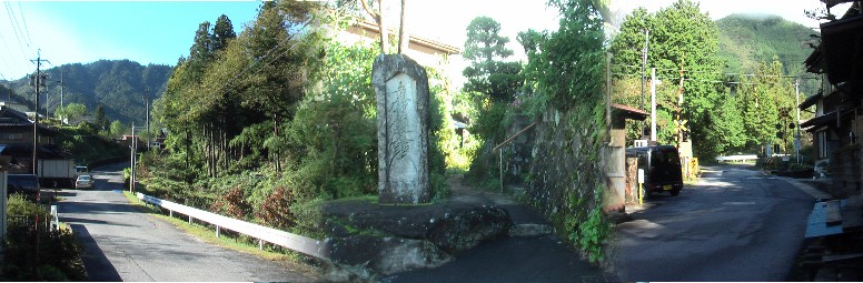 踏み切りを越える（右端）とまもなく野尻宿高札場跡（中）ですが撤去されて 隣接する題目碑（中）。集落へ行く街道（左）。