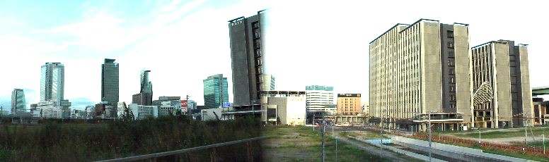 駅前広場（未整備）からひと際目立つ愛知大学名古屋キャンパスと付近から見る名駅前方面。