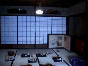 旅人が宿で寛ぐ夕食の膳が並べてある