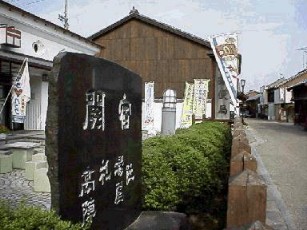 白壁塗りの凝った建物の郵便局に建つ高札場本陣跡の記念碑