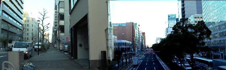 伝馬町通りが途切れ東を振り返る。右：日銀前歩道橋越えとなり、伏見通り南方 （熱田神宮）を撮る。夕日がビルに反射しまぶしい。