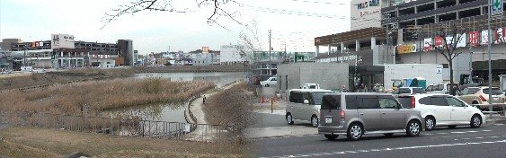 右：工事が最終場面となっている徳重駅（中央白く低い建物） 付近2010.12.16写す。左；駅前にある要池(浸水被害を防ぐため 雨水を一時的に貯水する池です)