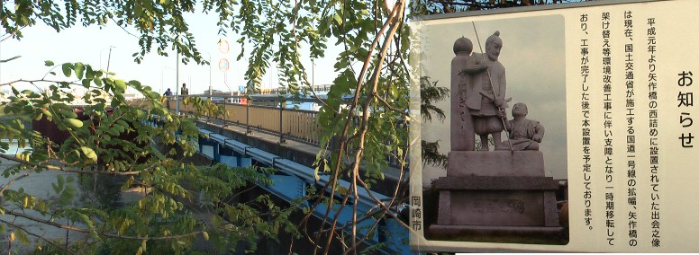 矢作橋西に建つ工事中の日吉丸、蜂須賀小六の出会い像の説明写真。 矢作橋西詰め