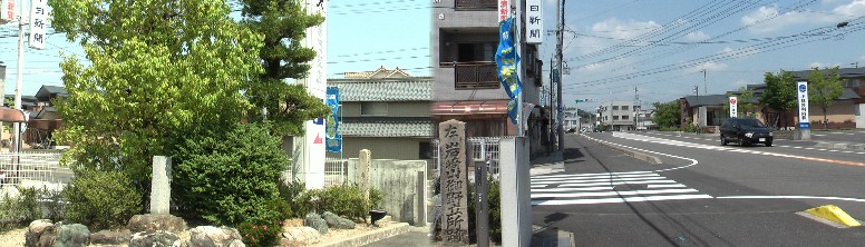 ja味岡支店のポケットパークに立つ岩崎山御野立所跡の石碑(左)。右は同支店前の街道 岩崎山御野立所跡。