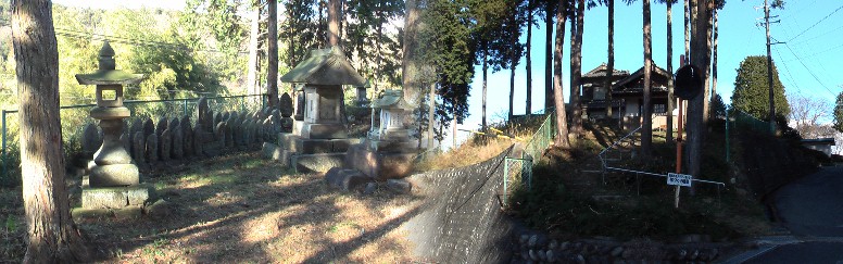 街道右側高い石垣の上に庚申堂（右）と境内の庚申塚。