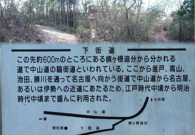 車の激しい１９号線を横断して山道を歩く。槙ケ根追分まで約６００ｍ地点の標識。上の写真は 標識付近の街道。 約６００ｍ地点の標識