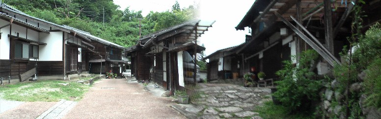 石畳の坂を登ると大妻籠集落の民家。庭先(玄関先)を抜けて峠へ向かう。