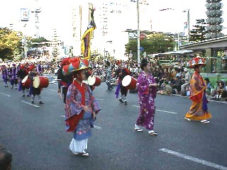 右、行列の最後を行くシャチばやし隊 左、沖縄エイサー踊り。