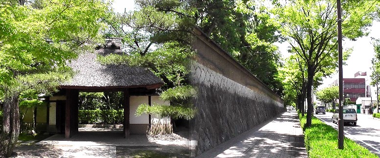 貞照院の茅葺き門（左）。年月を重ねた風情あふれる石垣の市道（右）。 貞照院案内板